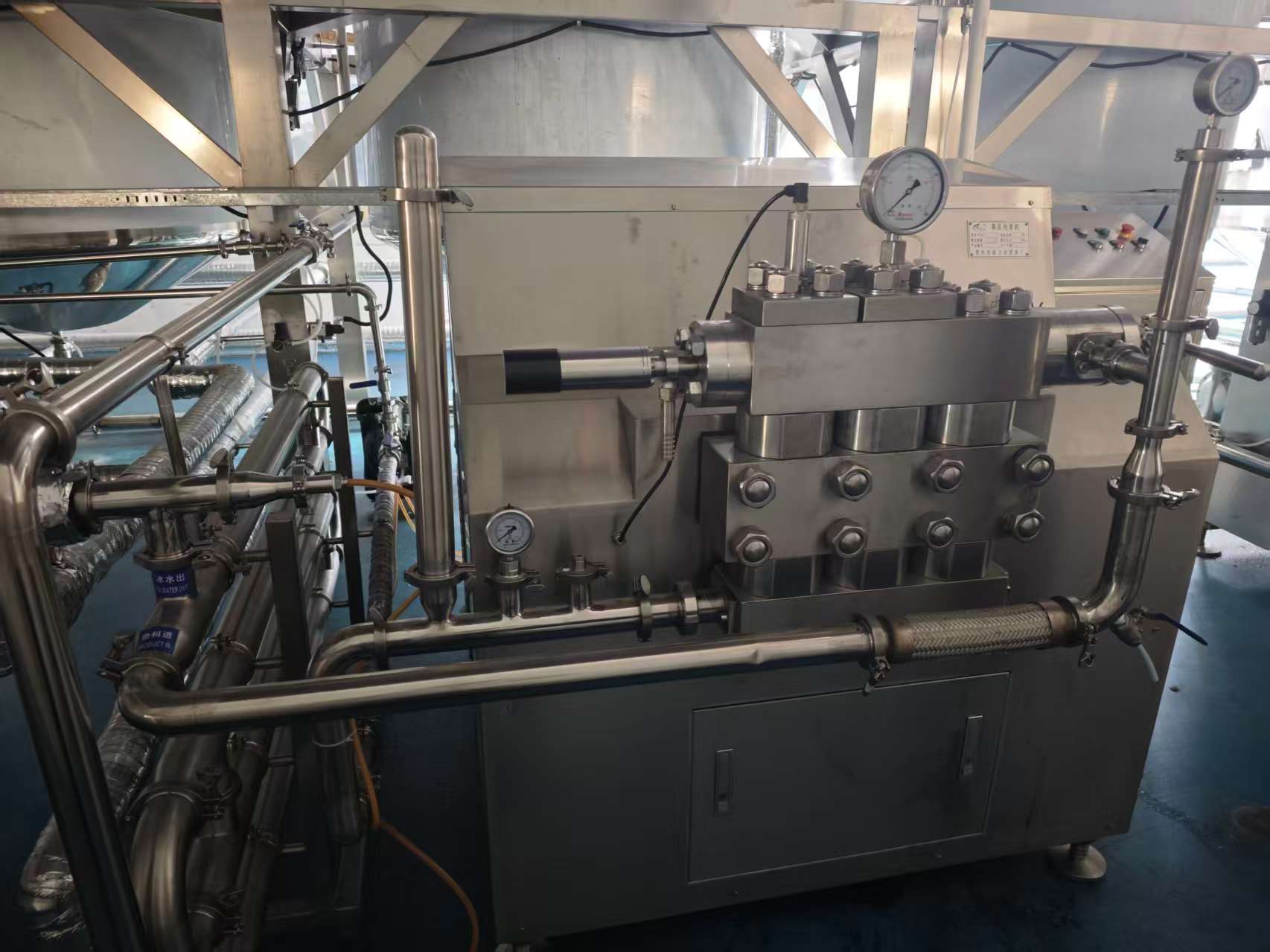 Pressure-monitored processing line with stainless piping and gauges.