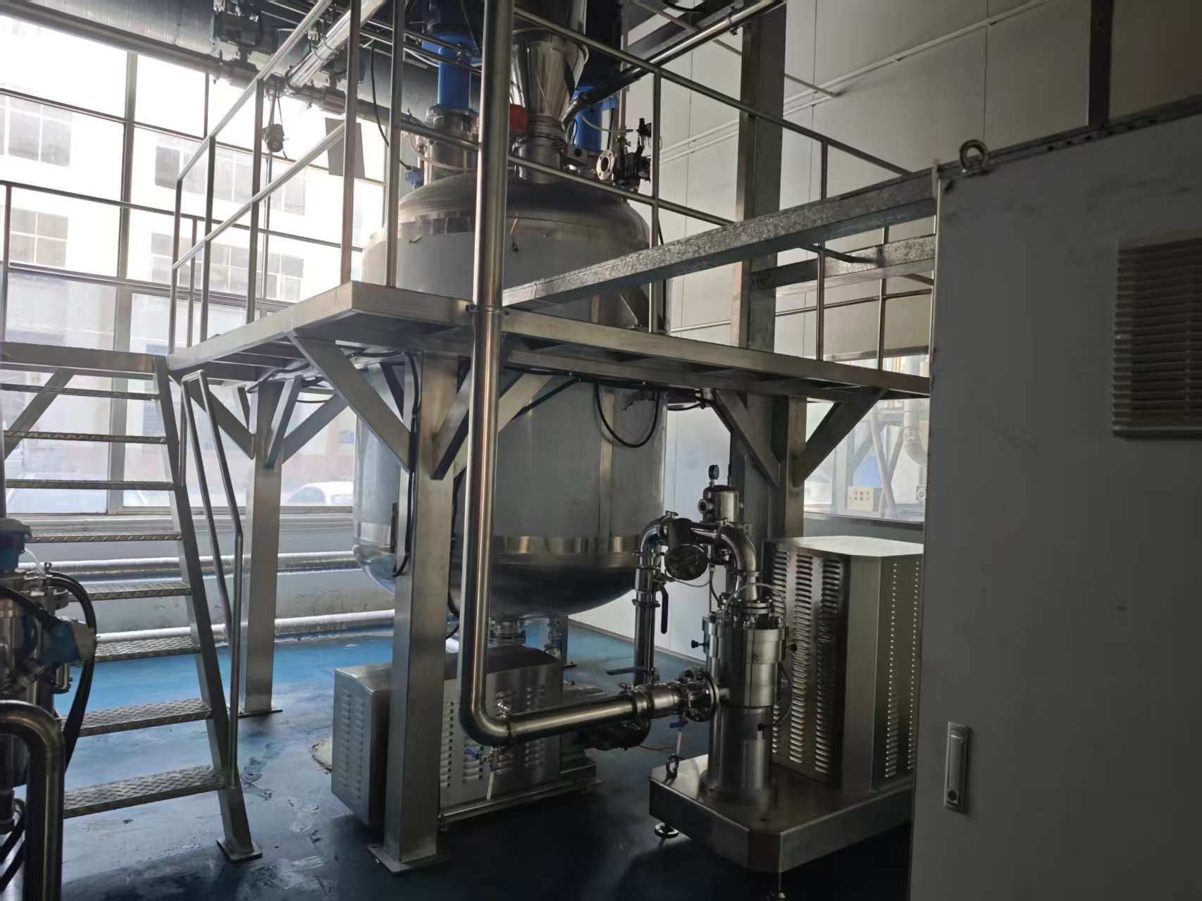 Production vessel platform with stainless piping and access stairs.