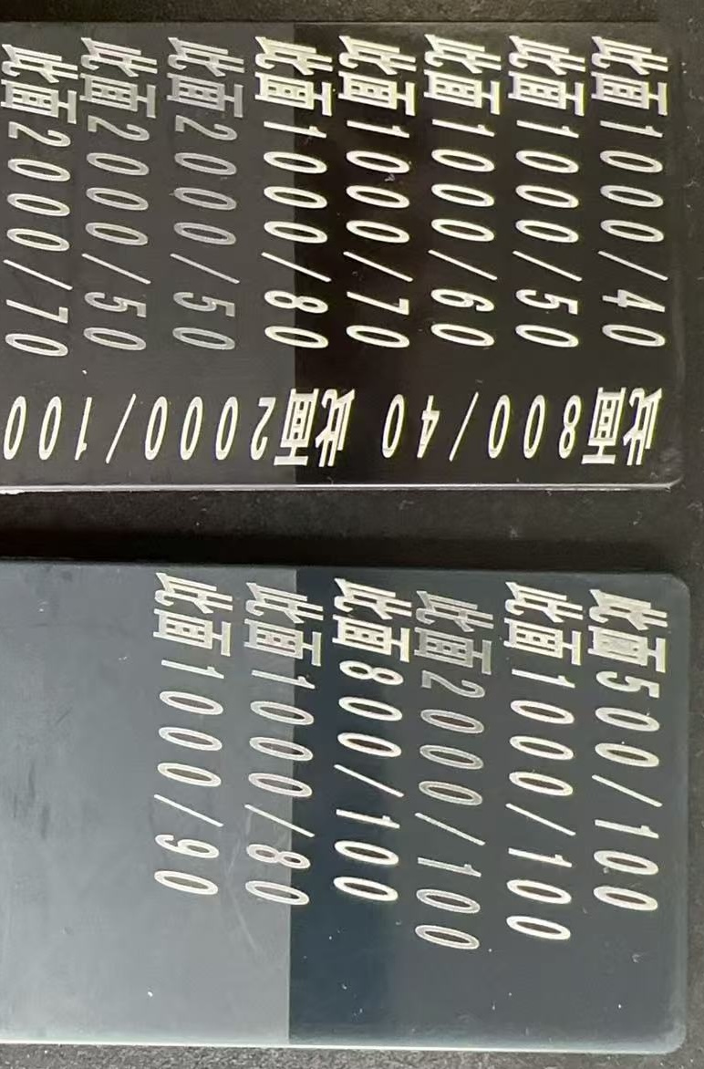 Black polymer laser-marking test plaques labeled Titanium Oxide Black (PBK-535), also called Black Titania, showing light visual marks.